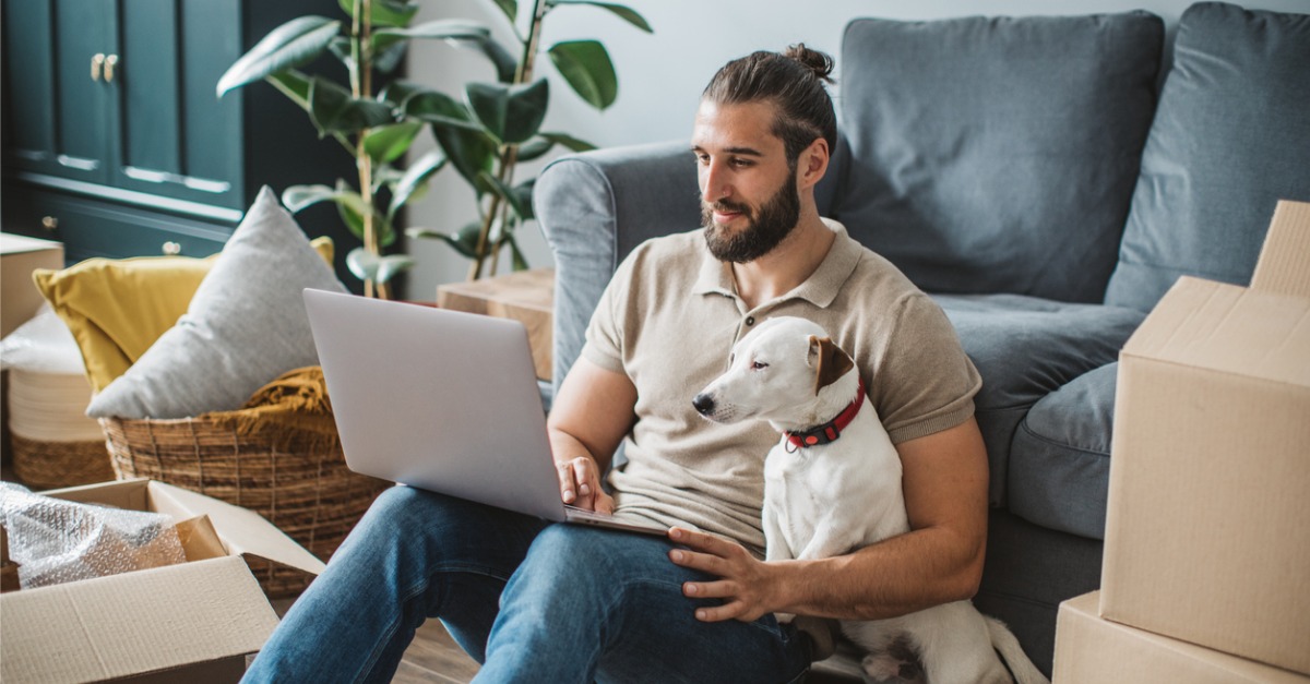 Photo of a man and his dog contacting customer service on a laptop, hoping for a great customer experience.