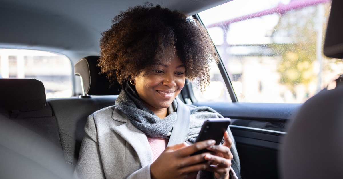 Photo of a woman looking at her phone screen after receiving proactive communication.