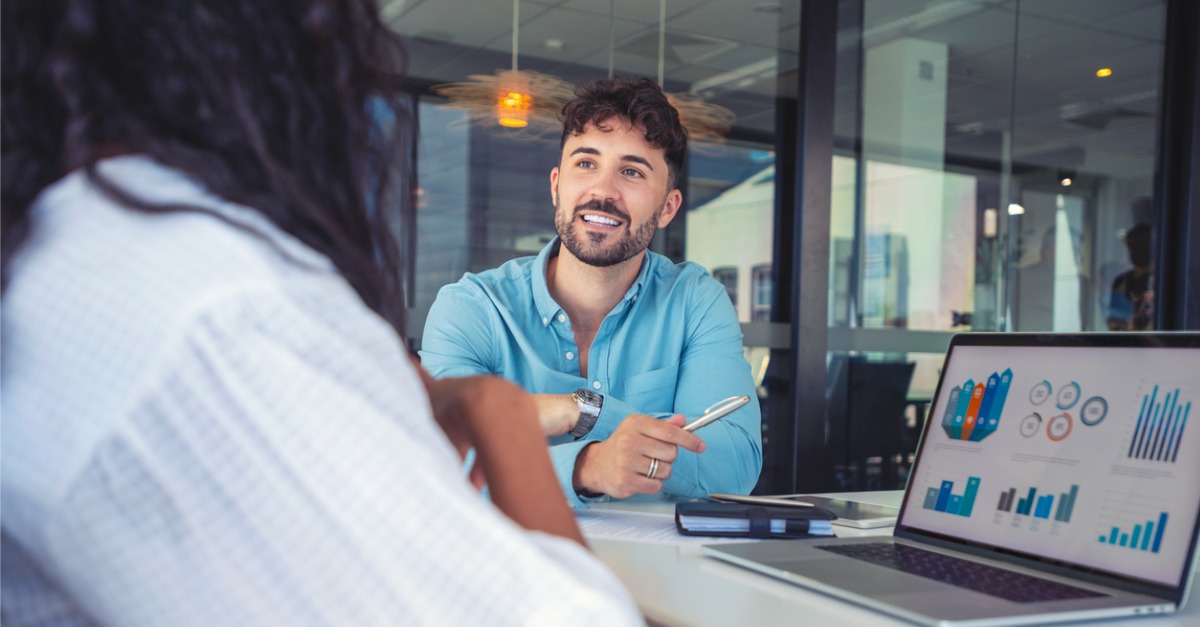 An HR rep speaks with an employee. AI can improve HR automation, so reps can devote more time to discussions like these.