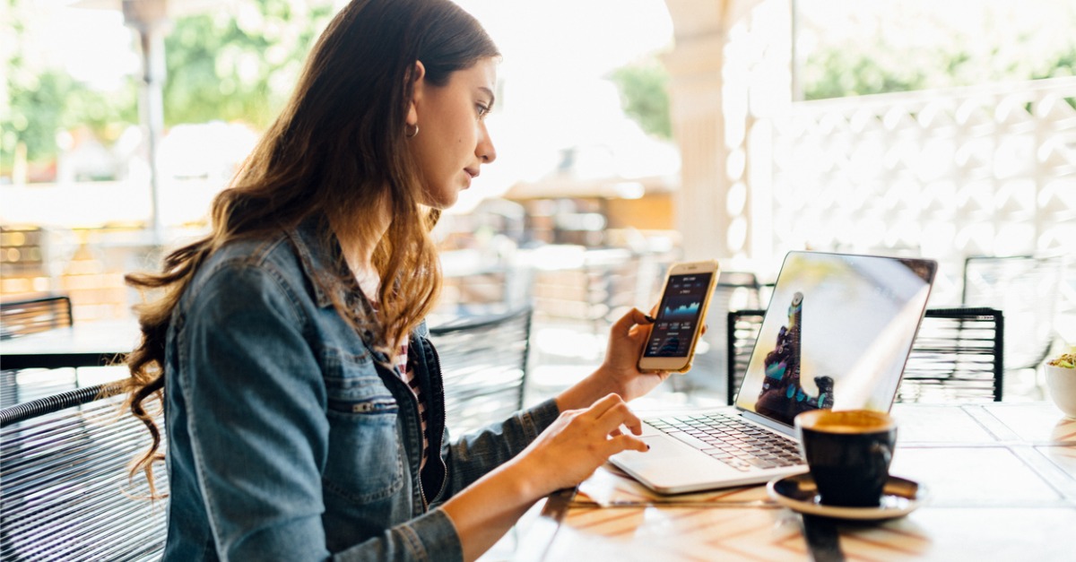 A woman looks at her phone while computer telephony integration helps navigate her call through a contact center.